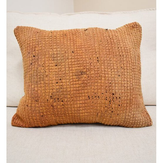 Marokkaans kussen P601 op bank, handgemaakt van vintage Berberkleed. Unieke bohemian touch voor woon- of slaapkamer.