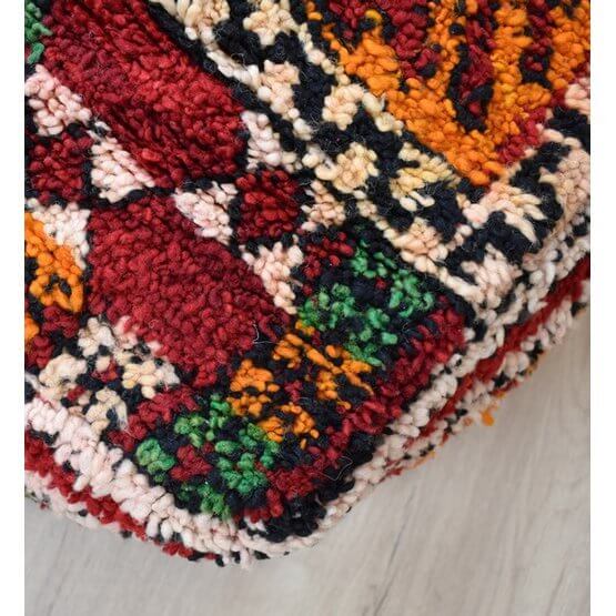 Detail van een kleurrijk Marokkaans vloerkussen, handgemaakt van vintage berberkleed met bohemian motief, ideale eyecatcher.