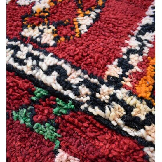 Marokkaans vloerkussen detail met kleurrijk vintage berberpatroon, unieke stuk handgemaakt voor een bohemian sfeer.