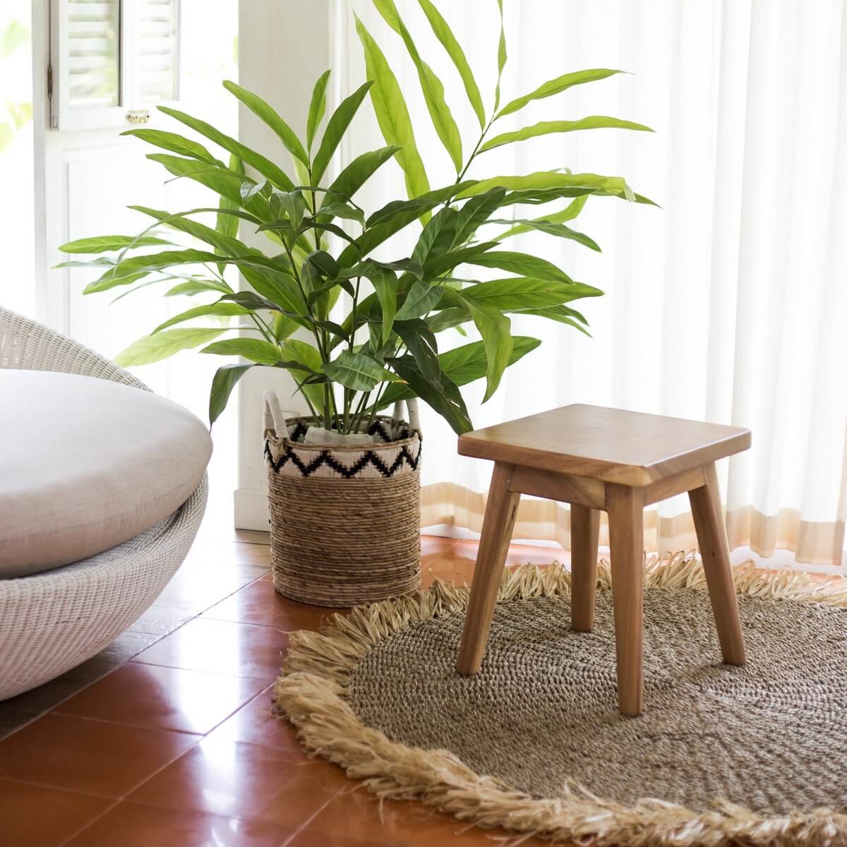 Opbergmand van bananenvezel met zigzagpatroon naast groene plant in een gezellig interieur, perfect voor opslag en decoratie.