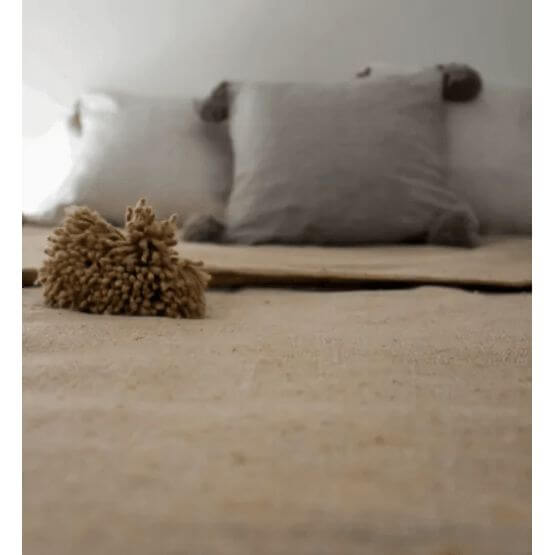 Pompondeken beige met pompons op bed, Marokkaans design voor een stijlvol en knus interieur.