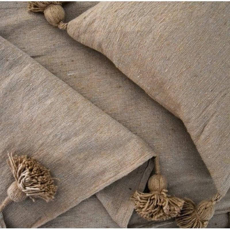Marokkaanse pom pom deken in beige, perfect voor een gezellige inrichting. Geschikt voor moderne en bohemien woonstijlen.