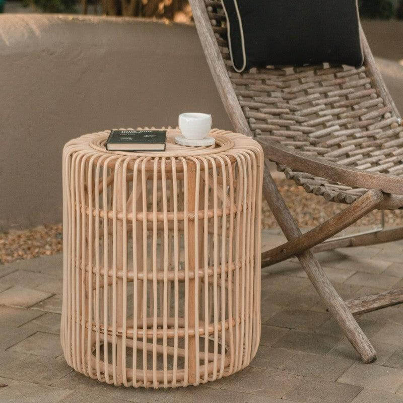 Rotan bijzettafel ALAMAYA naast stoel, perfect voor buiten of binnen gebruik.