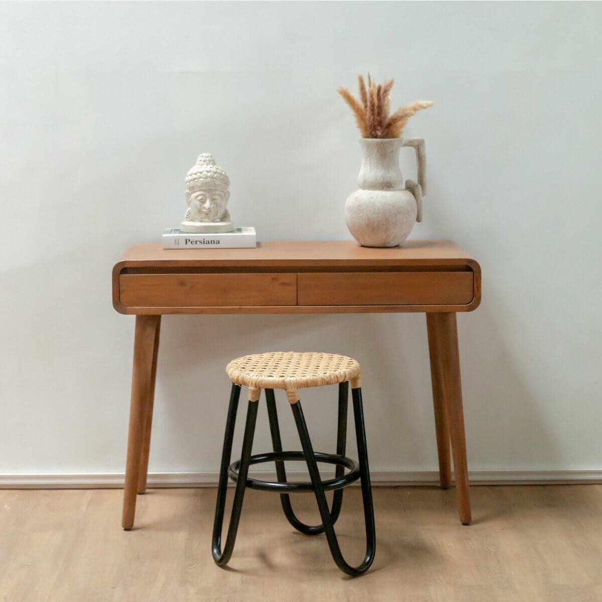 Rotan kruk KOLAKA zwart Ø35 cm met geweven zitting voor moderne interieurs, bij houten tafel met decoratie.