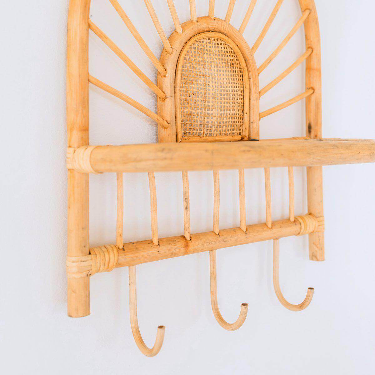 Handgemaakte rotan wandplank in boho-stijl met drie haken en zonnestraalpatroon, ideaal voor een tropische, warme uitstraling in huis.