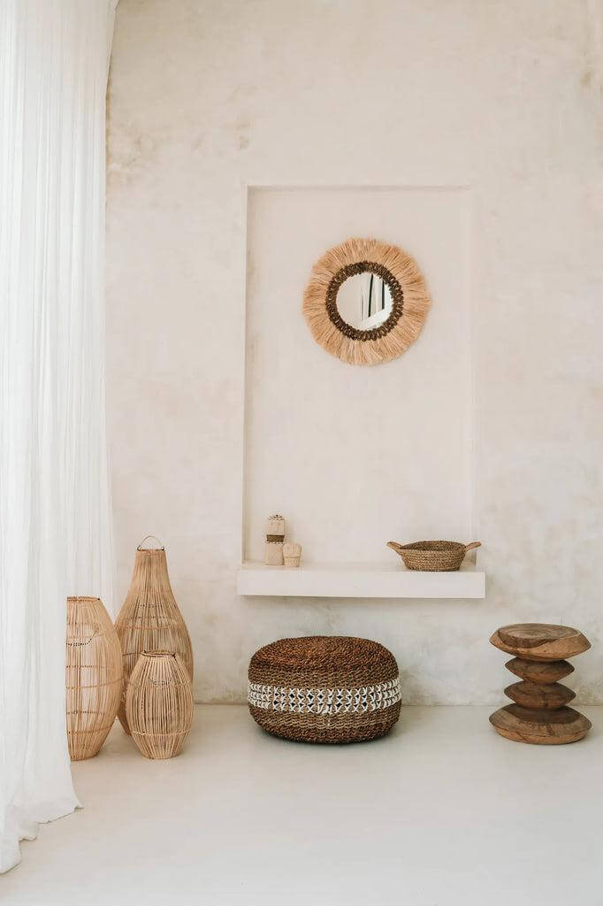 Alt Tag: Gezellige woonkamerinrichting met rieten decor, rotan vazen en spiegel. Perfecte sfeer voor een knusse en stijlvolle ruimte.