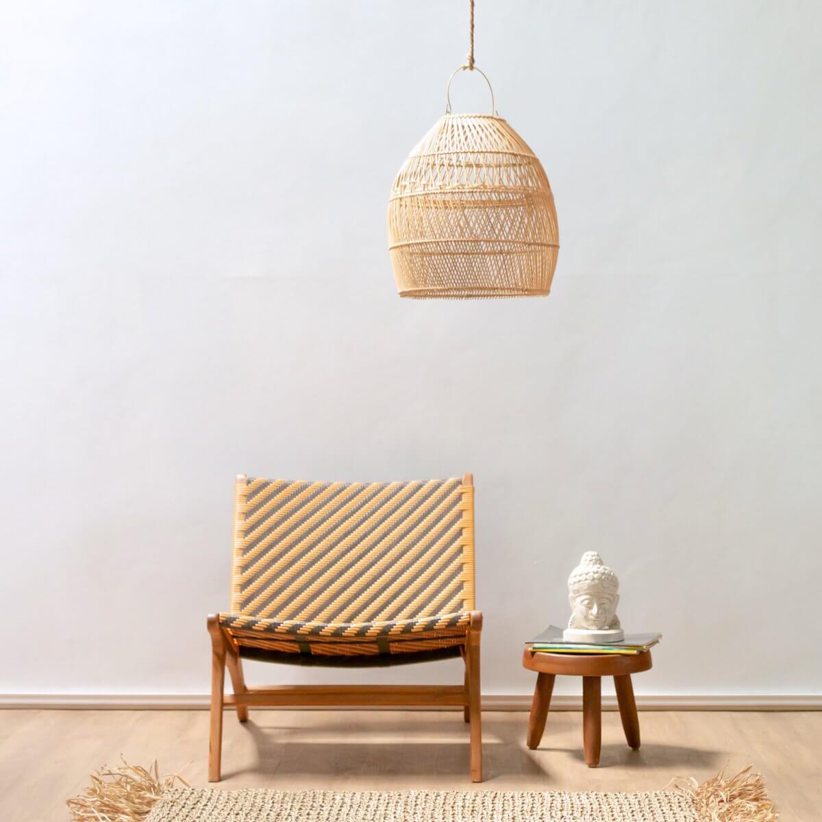 Rotanlamp Seminyak boven een boho stoel en tafel in een minimalistisch interieur, handgemaakt van duurzaam rotan, plasticvrij verpakt.