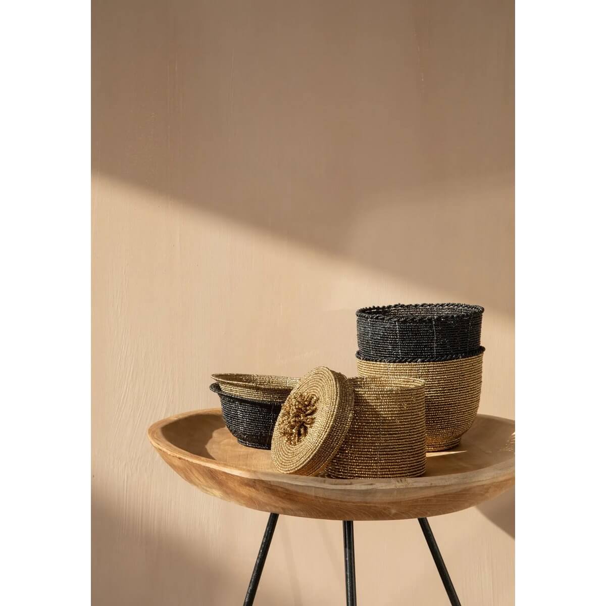 Bohemian beaded bowls in black and gold on a wooden table, perfect for storage and decor in any room.