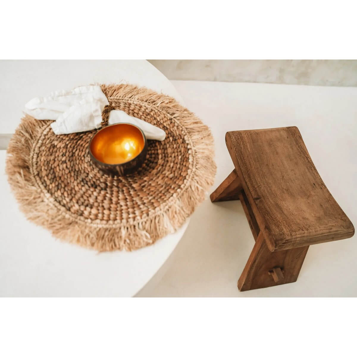 Bohemian chic setup with a natural gold Coco Food Bowl resting on a woven mat, complemented by rustic wooden decor.