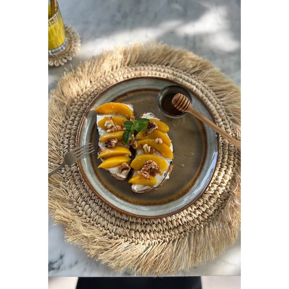 Versierd Comporta Salad Plate met mango en walnoten op stro placemat