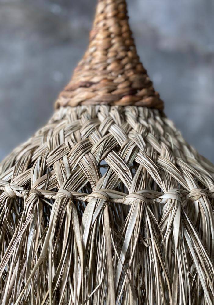 Natuurlijke hanglamp geweven van sisal en bananenblad, creëert een strandvibe in huis.