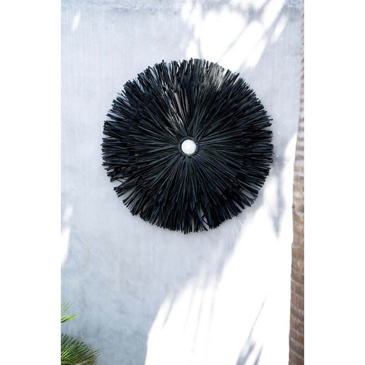 Raffia Juju - Zwart op muur, bohemien wanddecoratie voor interieur of tuin, gemaakt van natuurlijk materiaal, in schaduwrijke omgeving.