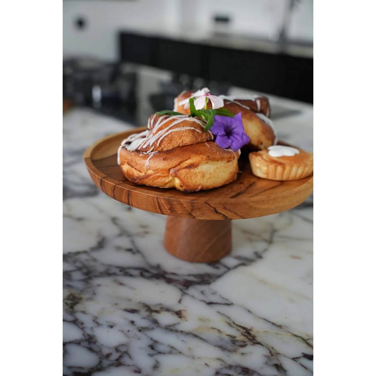 Elegant Teak Root Cake Dish displaying pastries on marble table, perfect for a bohemian touch to any decor.