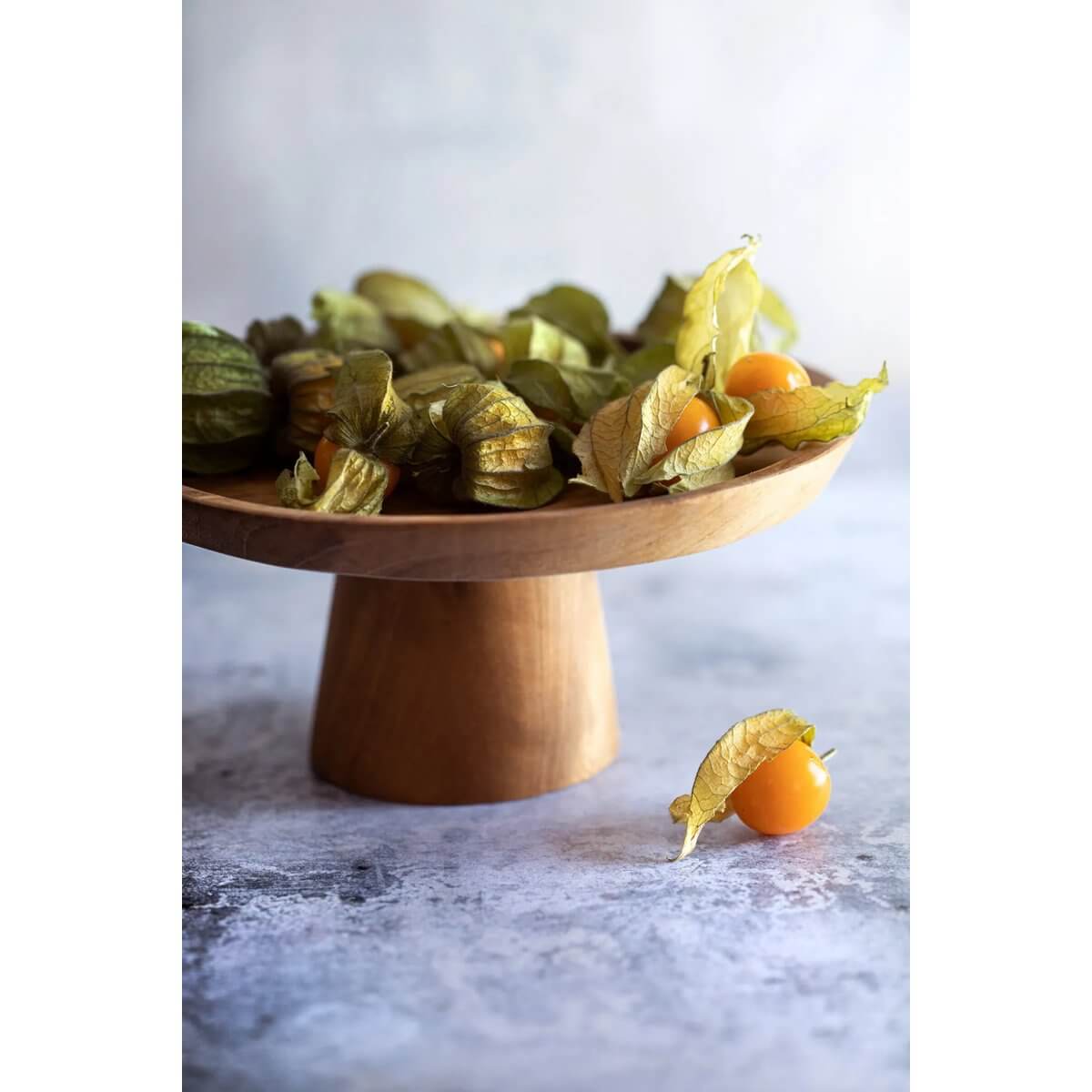 Bohemian Teak Root Cake Dish displaying fresh golden berries, perfect for serving desserts or sweets, enhancing elegant table decor.