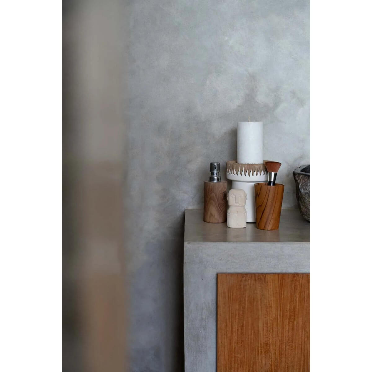 Stylish concrete shelf with decorative candle, wooden cups, and minimalist decor, adding a bohemian touch to a modern home.