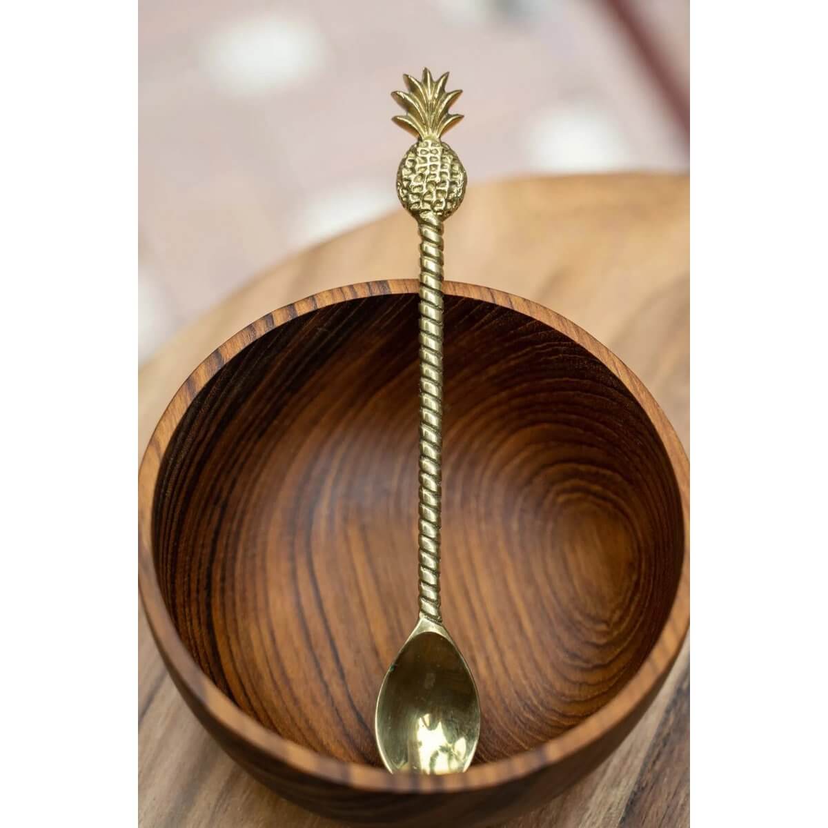 Bohemian teak salad bowl with a brass pineapple spoon, perfect for stylish dining; eco-friendly and photogenic. Bazar Bizar Living.