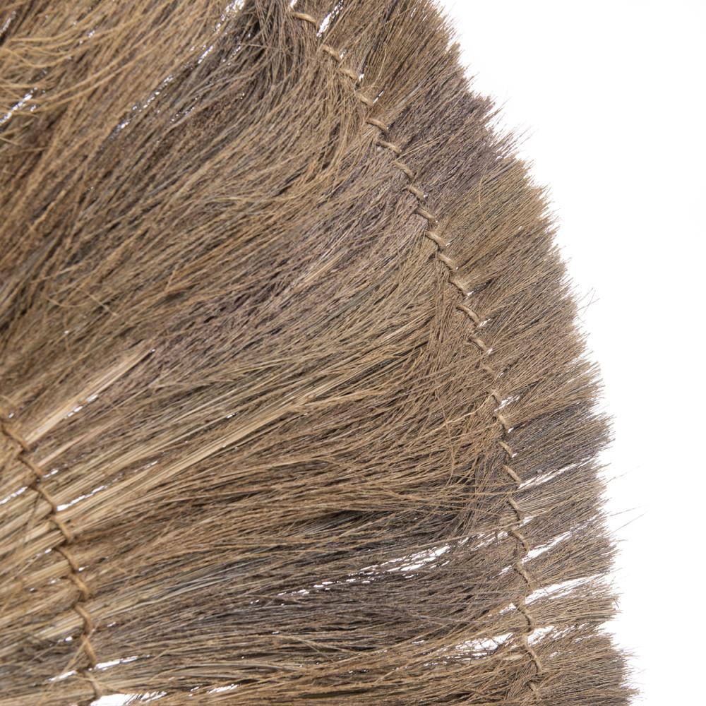 Close-up van de Chi-Chi wandlamp gemaakt van gras en messing, toont de gedetailleerde geweven structuur.