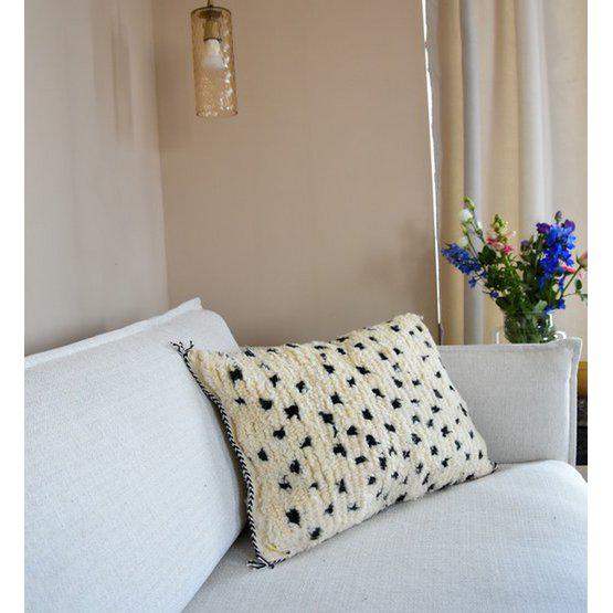 Beni Ouarain kussen met gestikte zijkanten op een witte bank, prachtig in Scandinavische en bohemien interieurs.