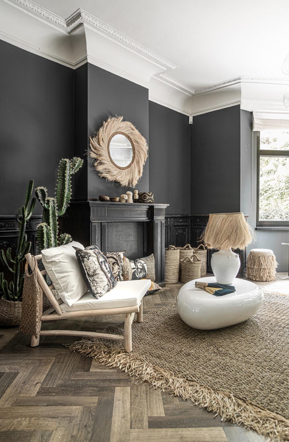 Gezellige woonkamer met De Island eenzitter, omringd door planten en rustieke decoraties, perfect voor ontspannende zomeravonden.