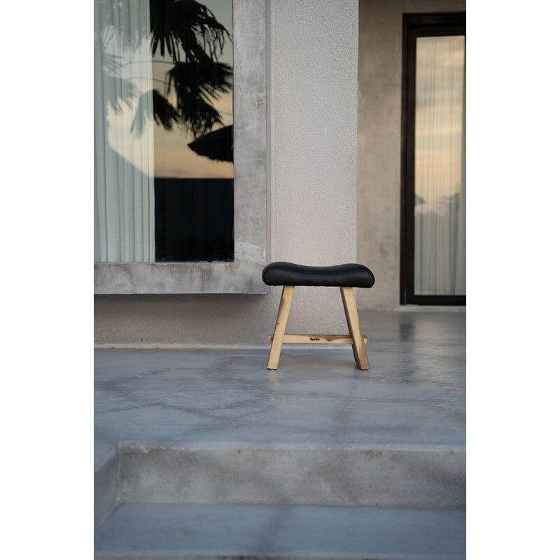 De Suar Kruk met zwart leder, natuurlijke houtkleur, veelzijdig in gebruik voor woonkamer, slaapkamer, badkamer. Hoogte 45 cm.