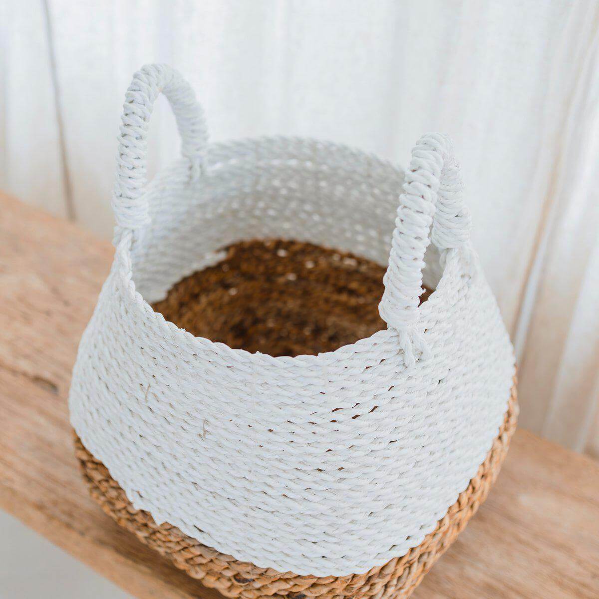 Alt Tag: Witte Majalengka opbergmand van bananenvezel op houten tafel, handgemaakt en stijlvol voor een moderne en natuurlijke inrichting.