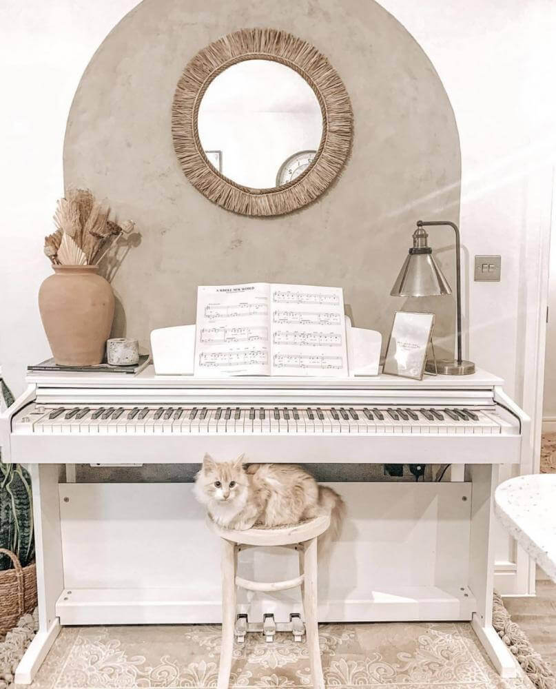 Katten voor piano met Boho spiegel The Tahiti, met Indonesische raffia, die een etnische en boho sfeer aan het interieur toevoegt.