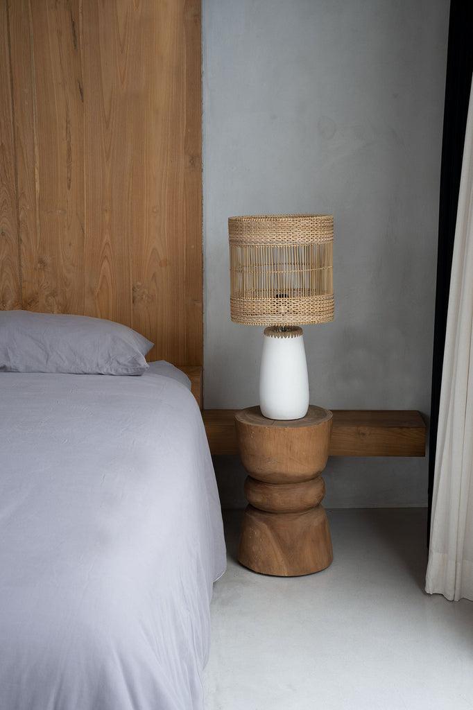 Elegant interieur met De Aukai kruk van suarhout als unieke bijzettafel naast het bed, natuurlijk kleur en design.
