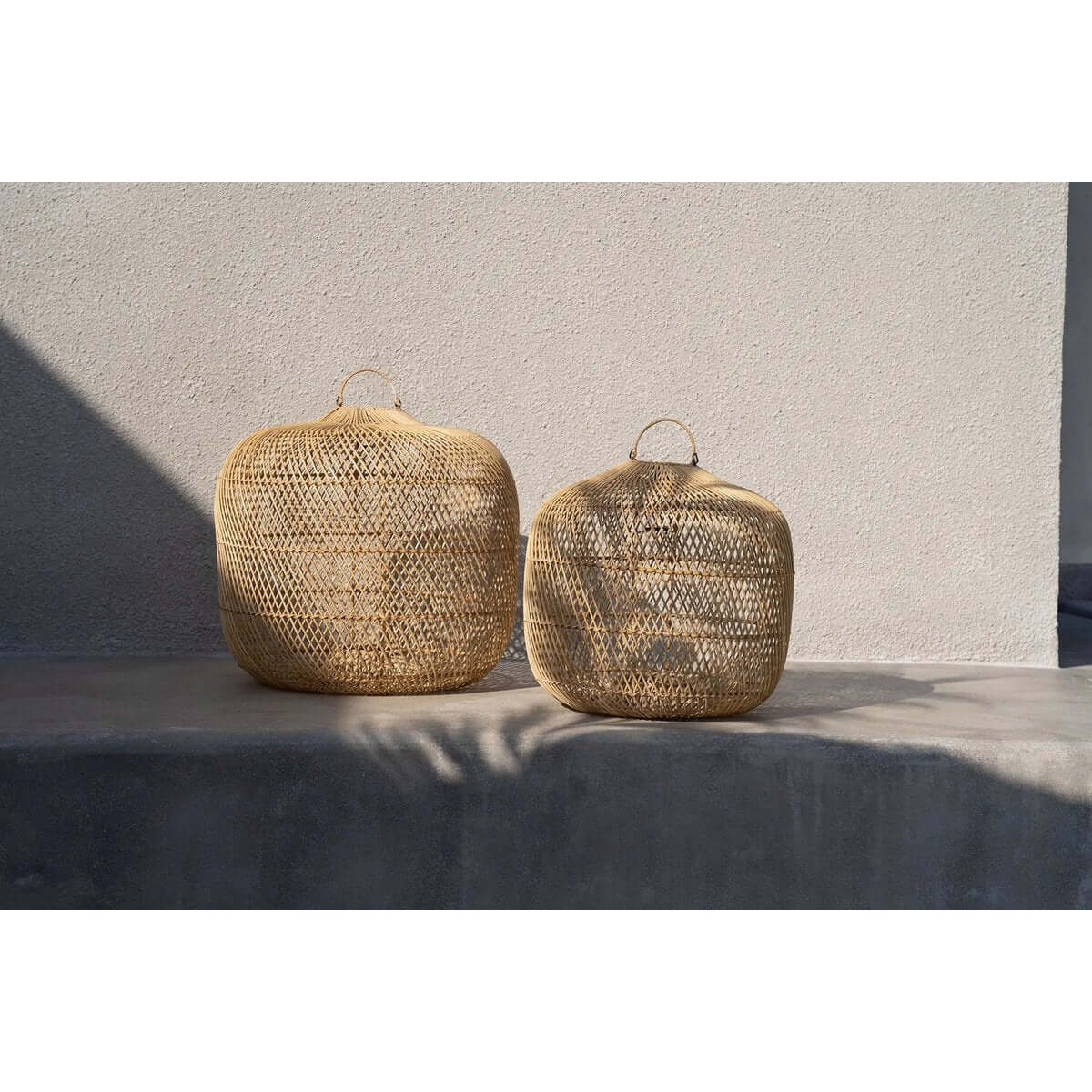 Bohemian-style De Batu Bolong natural rattan lampshades in two sizes, perfect for hanging or floor use. Versatile and chic design.