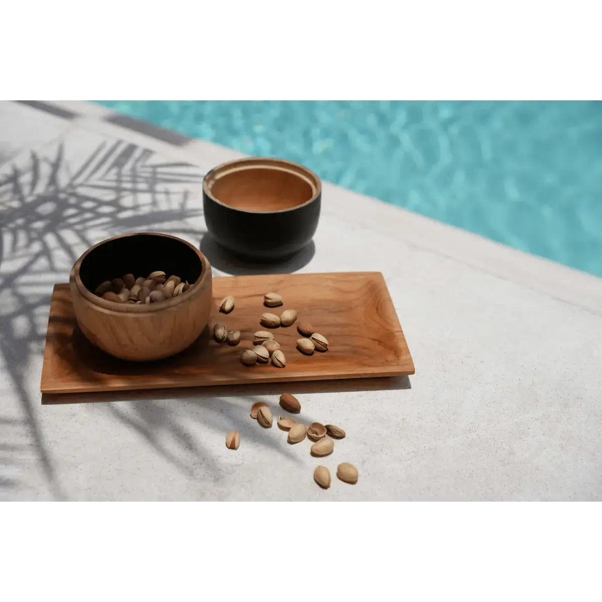 Bohemian style De Bondi Double Bowl teakhouten schalen by a pool, showcasing versatile elegance for storing accessories.