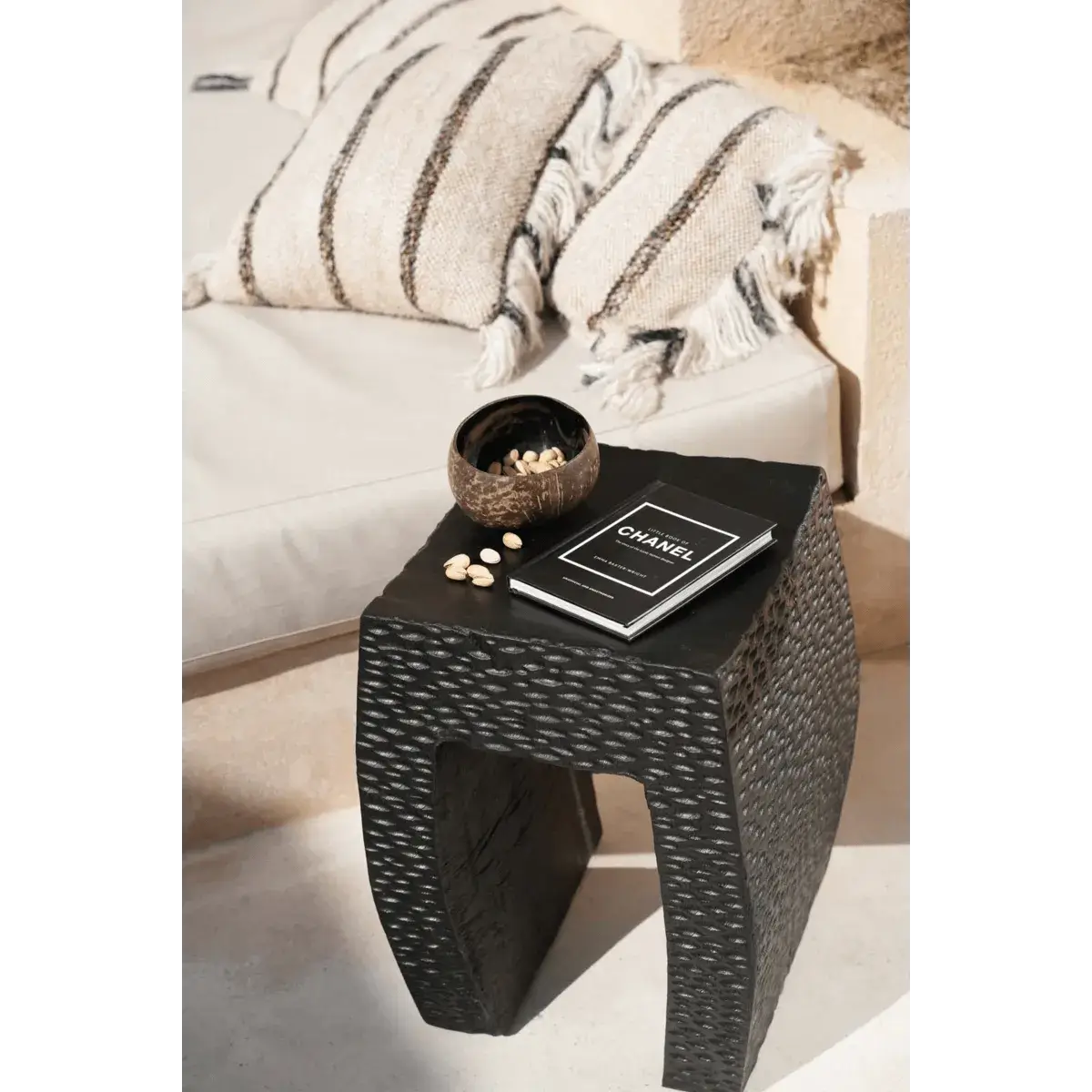Bohemian style setting with a natural black coconut bowl on a woven side table, perfect for breakfast or smoothie bowls.