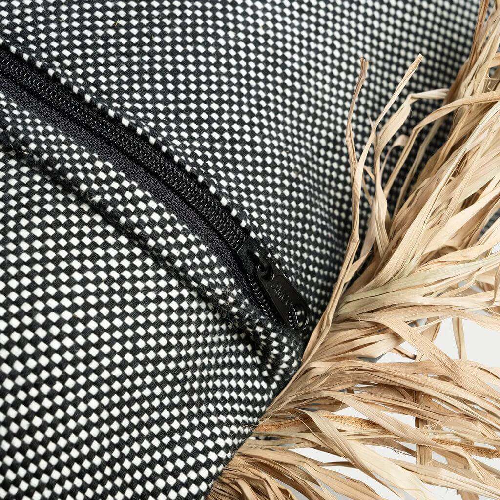 Detail van zwart-witte kussenhoes met raffia franjes, De Cotton Bonita, 60x60 cm. Perfect voor 'coastal' interieurstijlen.