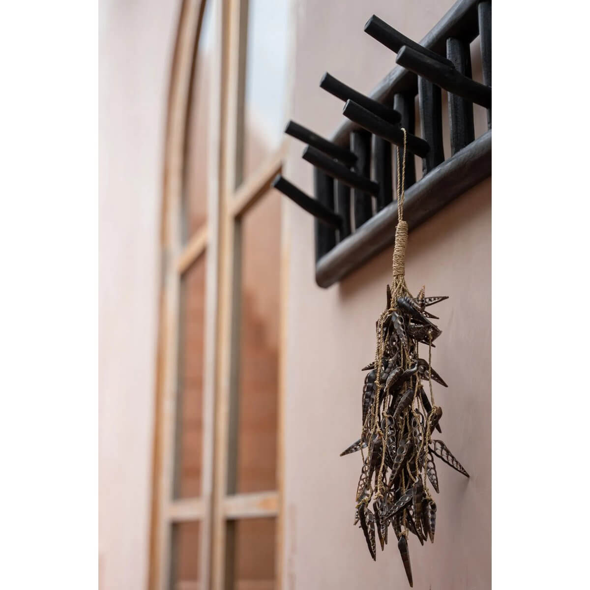 Bohemian decor: Brown unicorn horn shell tassel hanging on a wooden rack with rustic charm, 48cm long, versatile for keys or display.