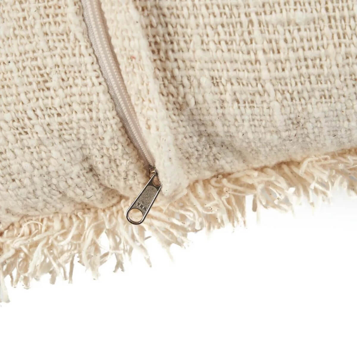 Close-up van een natuurlijke zwarte kussenhoes met rits, geweven textuur en franjes. Voeg Franse charme toe aan je interieur.