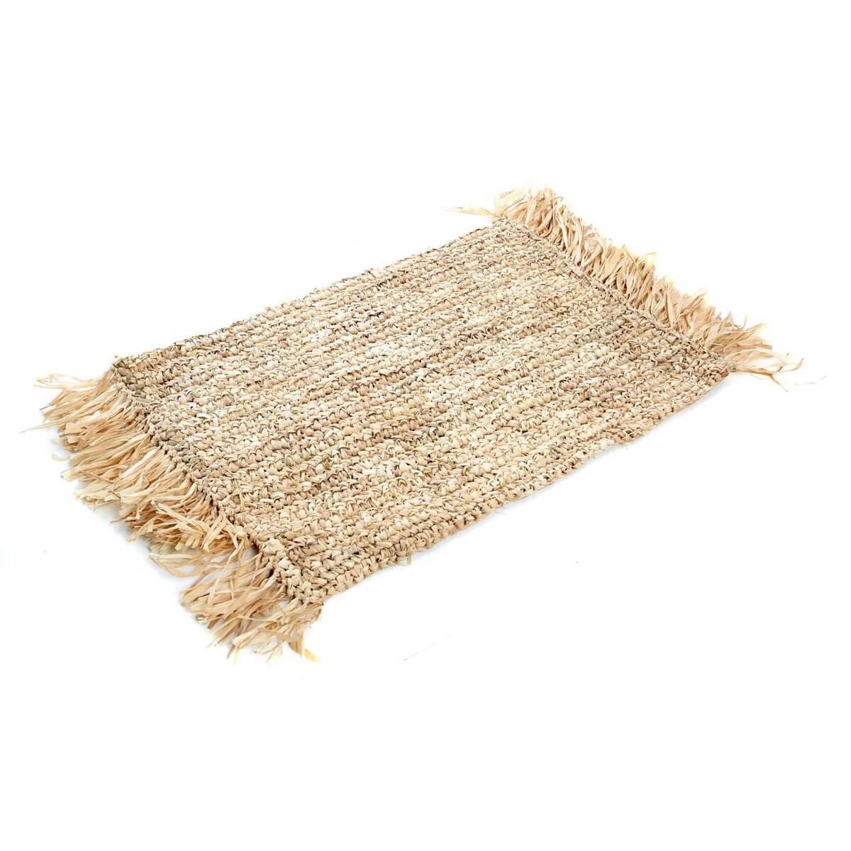 Bohemian style natural raffia placemat with fringes, handwoven for a chic table setting, from Bazar Bizar Living.