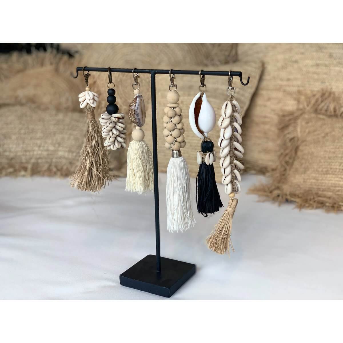 Bohemian style wooden bead keychains on display stand, featuring natural white colors and rustic cotton accents.
