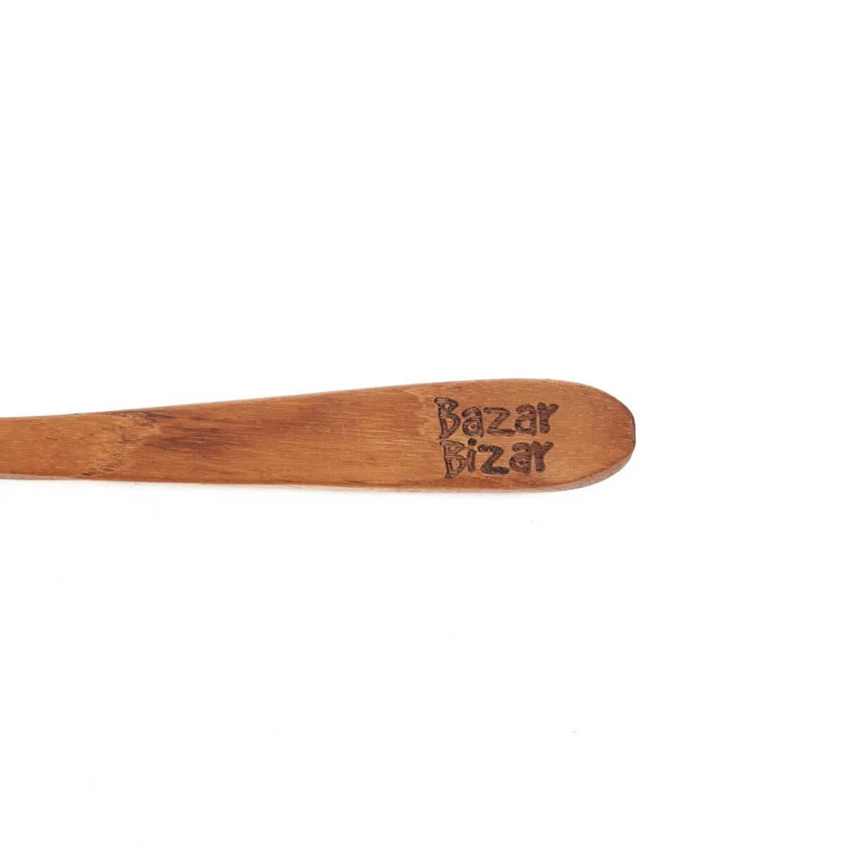 Bohemian teakwood spoon close-up showing textured grain and engraved design.