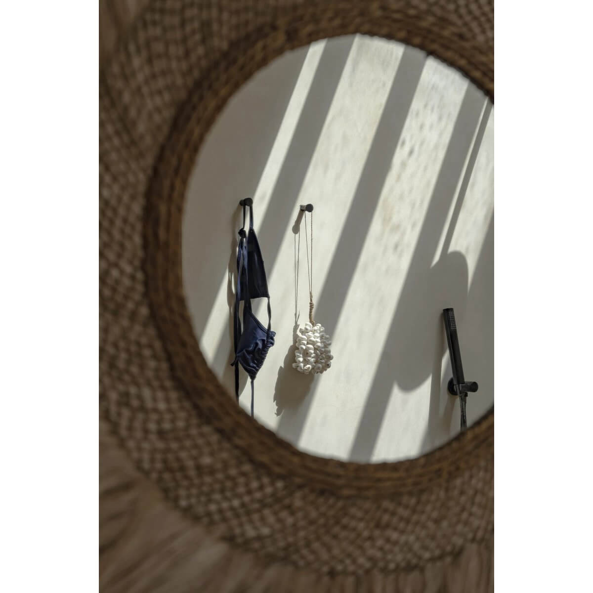 Mirror reflecting a Bohemian white shell hanger by Bazar Bizar Living, adding exotic flair to home decor, shown against a wall.