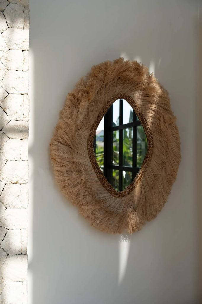 Ronde De La Duchessa spiegel met natuurlijke textuur, weerspiegelt een raam en tuin, geleverd met elegante, organische rand.