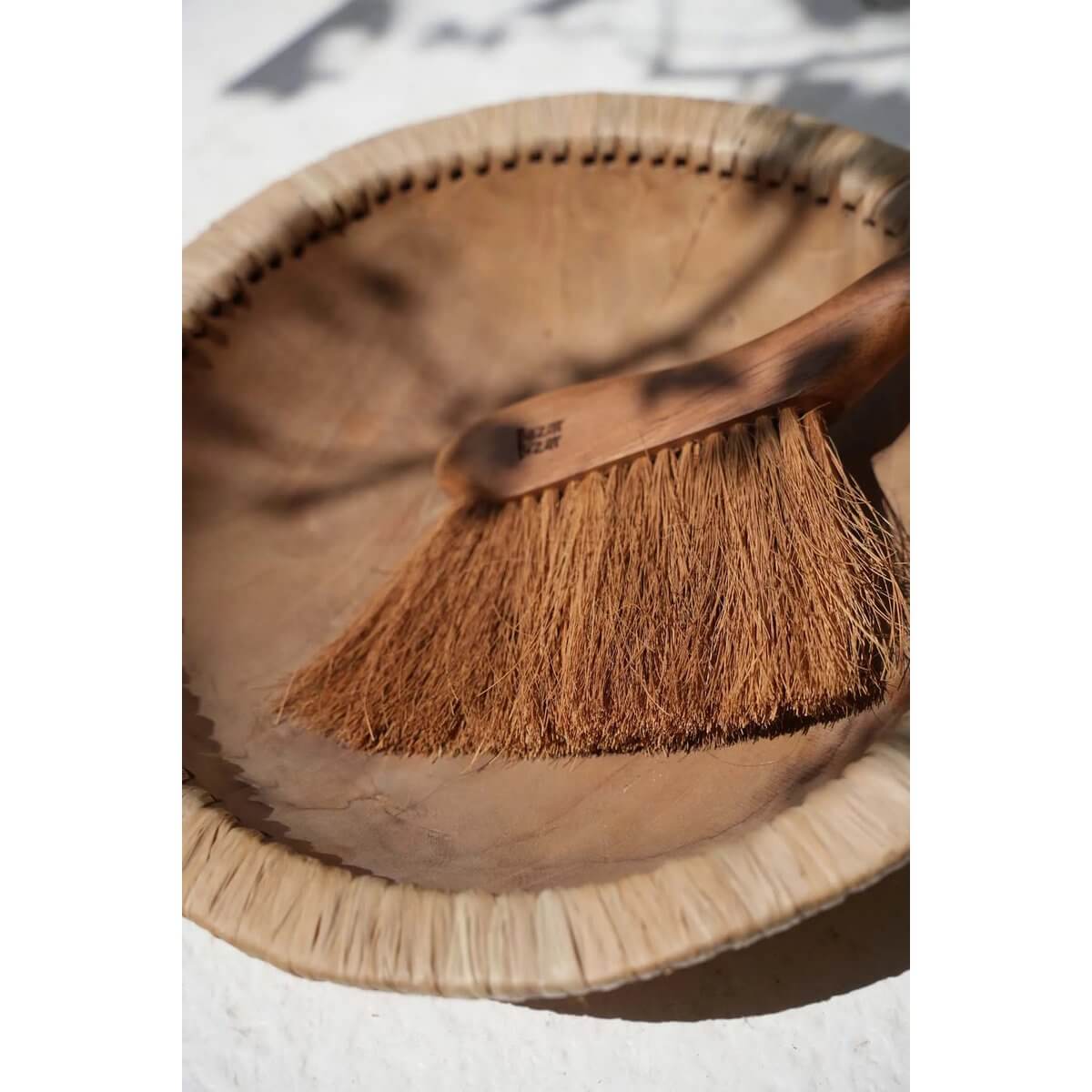 Bohemian-style Maha Brush made of sustainable teak on a rustic surface, perfect for elegant crumb cleanup in kitchens and dining areas.