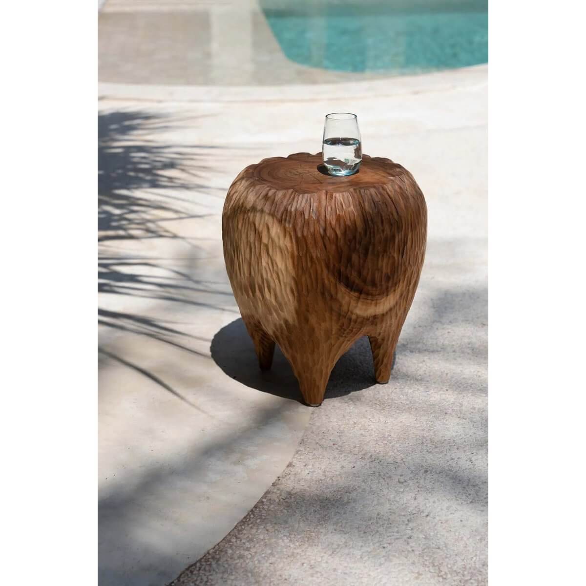 Bohemian style Maldives Stool made from suar wood by a pool, perfect for adding tropical elegance to any space.