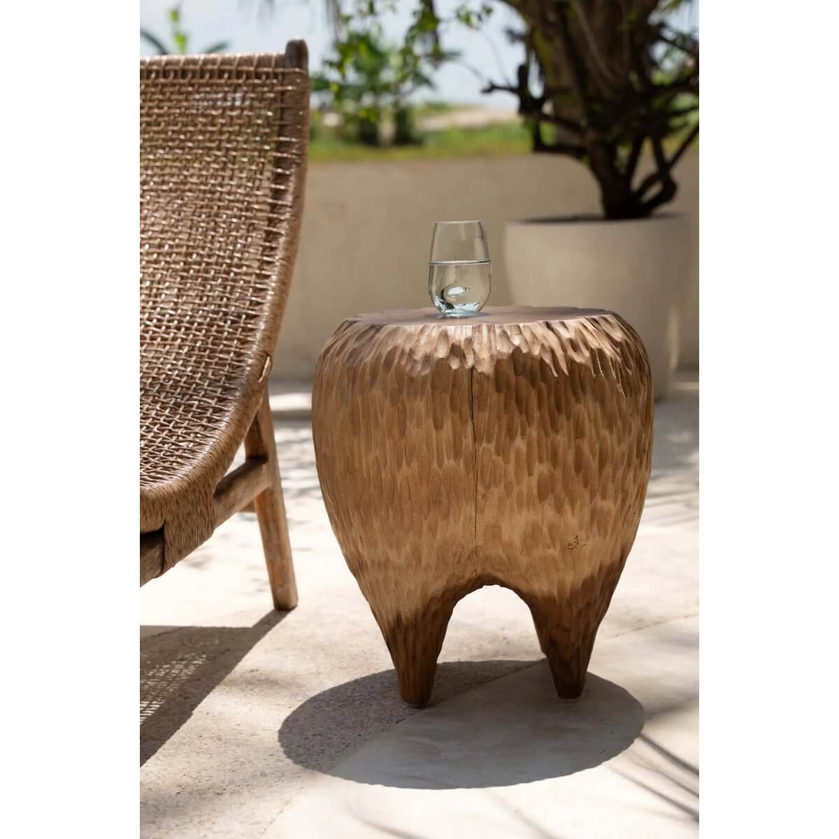 Bohemian-style Maldives Stool in natural Suar wood, adding tropical charm to outdoor patio decor.