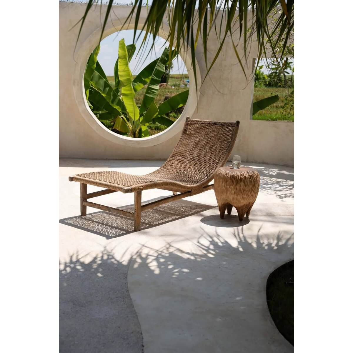 Bohemian outdoor setting with woven lounge chair and The Maldives Stool, evoking a serene tropical paradise ambiance.
