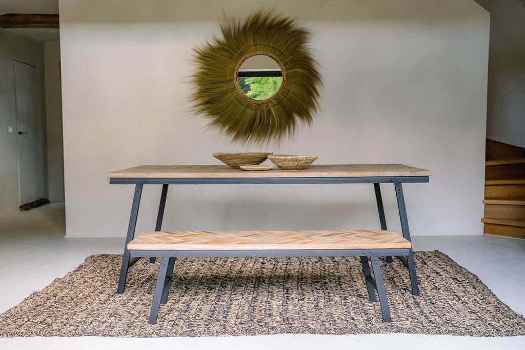 Majestueuze Mufasa XL wandspiegel met Rayung Grass omlijsting boven rustieke eettafel en bank.