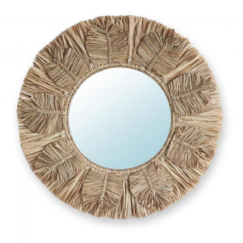 Ronde spiegel met raffia franjes en bladeren, omringd door kaurischelpen. Perfecte kunstzinnige decoratie voor elke kamer. Functie en schoonheid.