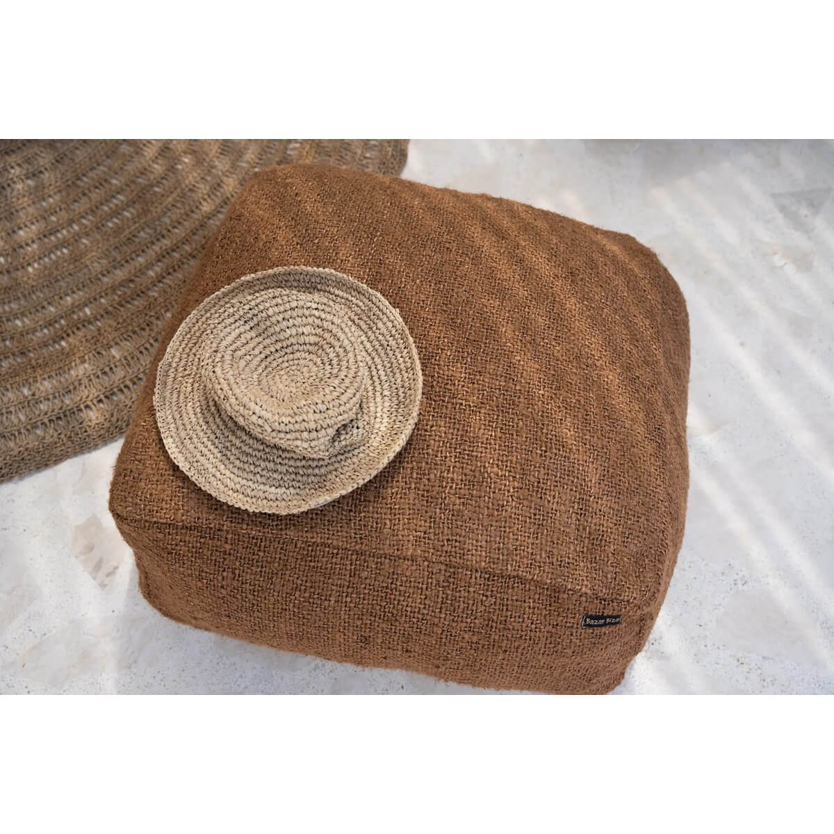 Bohemian natural sea-grass Pantai-hoed on brown textured cushion, perfect for stylish beach days.