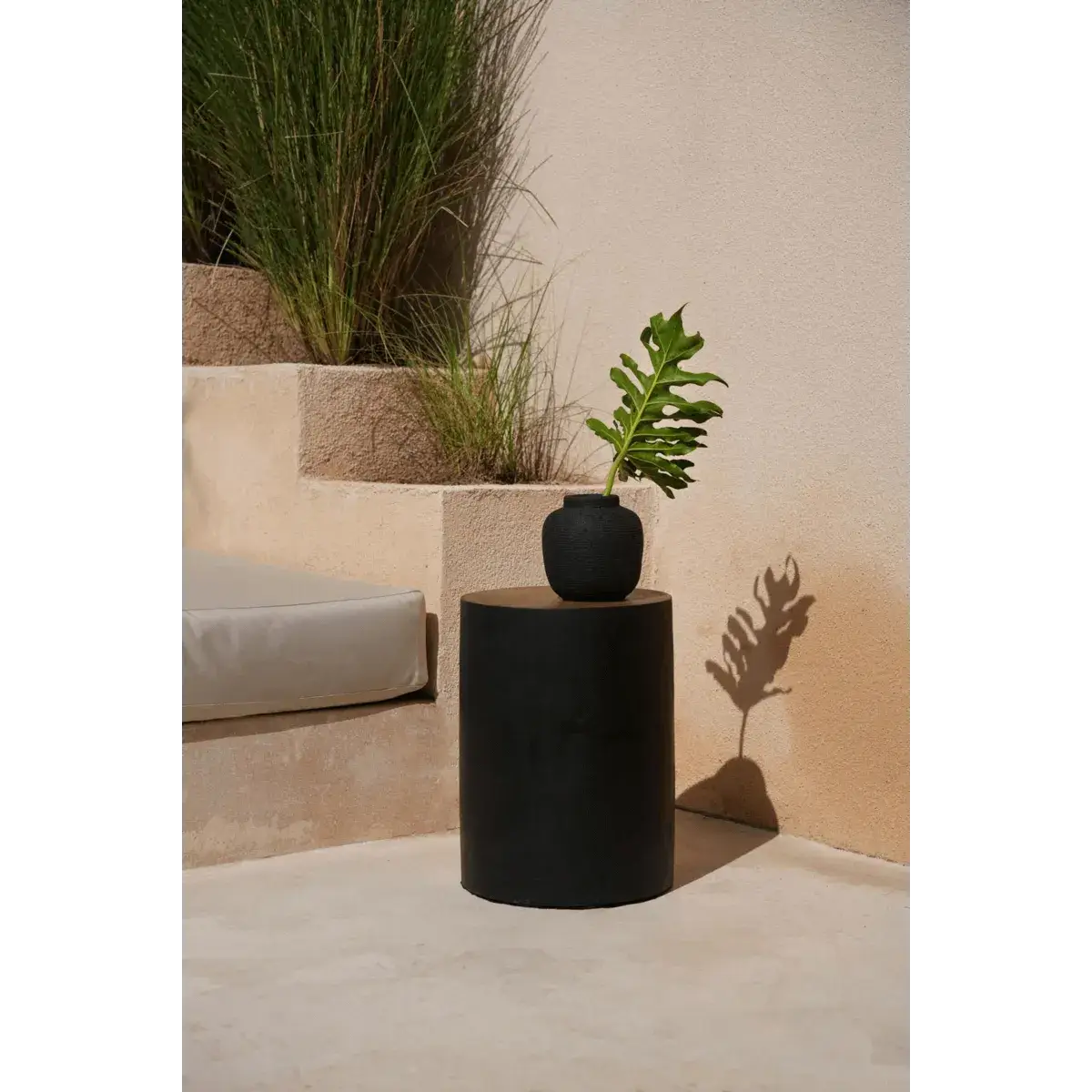 Sleek black Peaky vaas on outdoor table with greenery, perfect for Bohemian home decor.