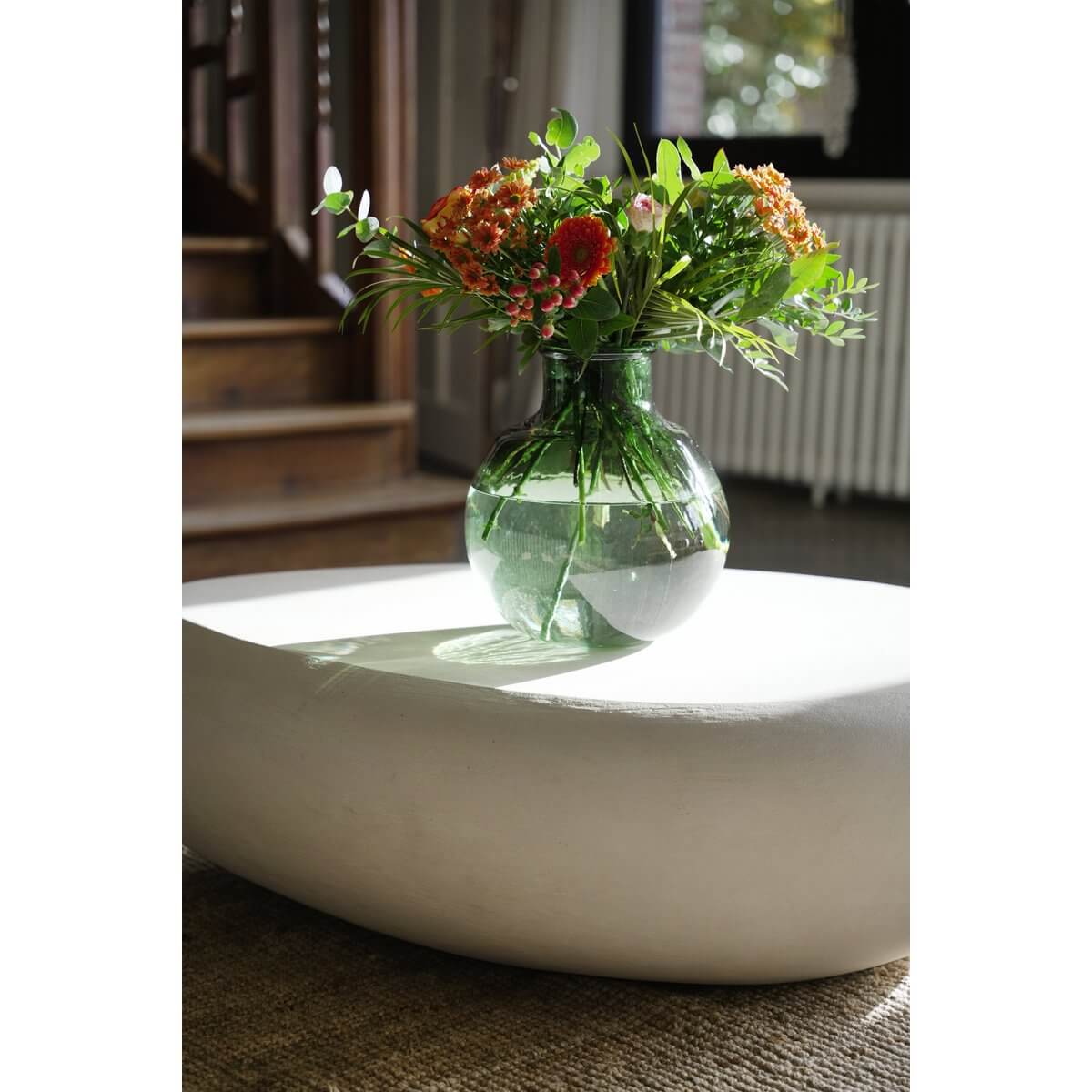 Bohemian style De Qiezi green vase made from recycled glass, showcasing vibrant flowers on a modern tabletop, perfect for contemporary decor.