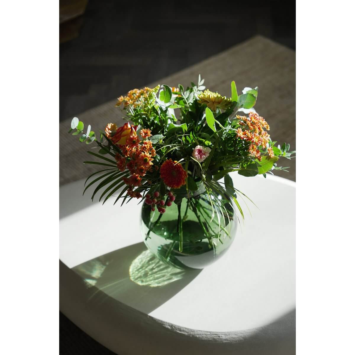 Bohemian style with De Qiezi Vaas in green, showcasing vibrant flowers. Made from recycled glass for an eco-chic, modern look.