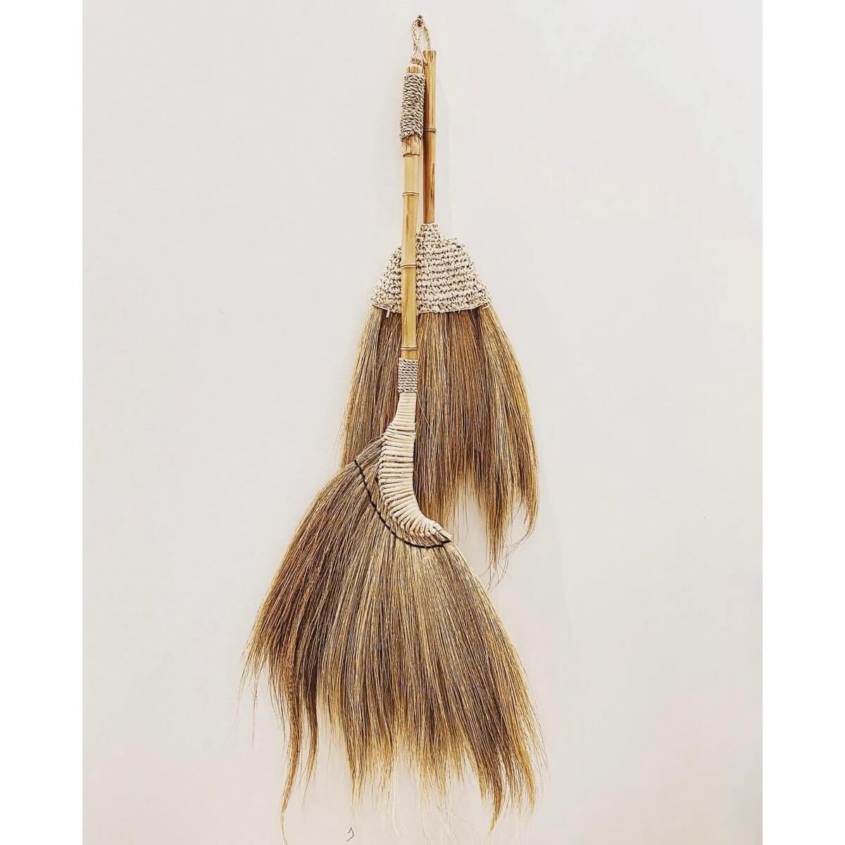 Handmade Bohemian Indonesian raffia broom with natural fibers, decorative and hangable. Perfect for indoor or covered outdoor decor.