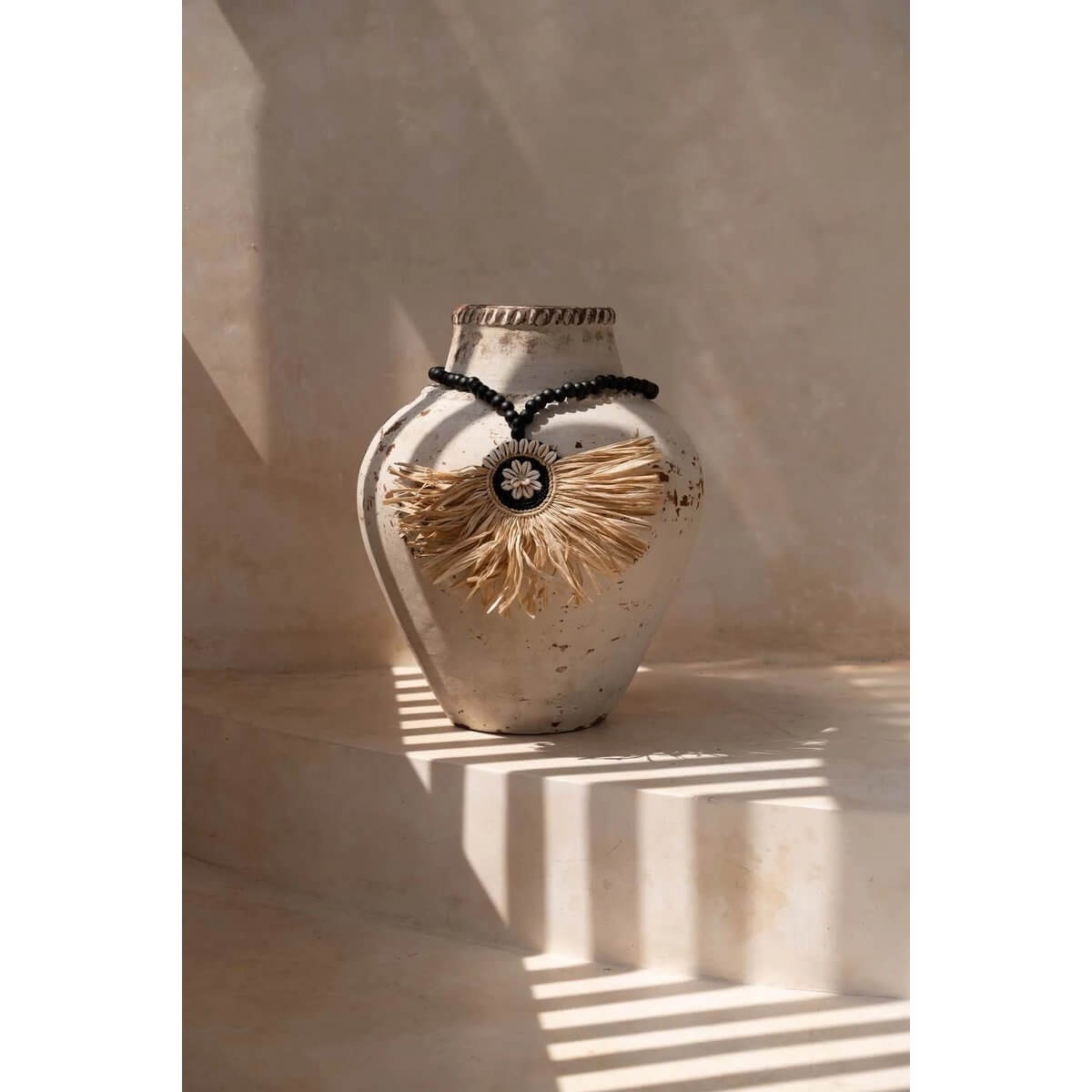 Bohemian vase with Raffia Mahkota Kwastje in natural black, adding elegance and style to any home decor.